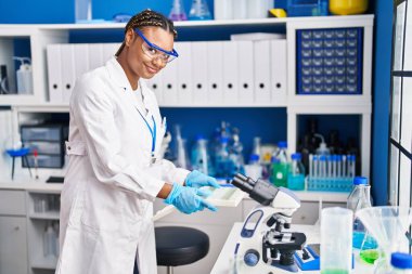 African american woman scientist holding samples at laboratory