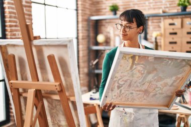 Güzel İspanyol kadın sanatçı gülümsüyor. Sanat stüdyosunda kendine güveni tam görünüyor.