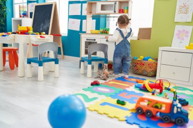 Sevimli sarışın çocuk anaokulunda mutfakta oyun oynuyor.