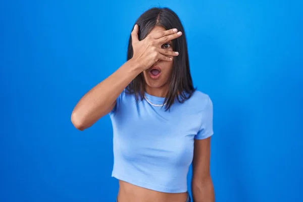Brunette Young Woman Standing Blue Background Peeking Shock Covering Face — Stok fotoğraf
