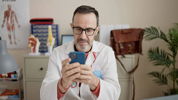 Middle Age Man Doctor Using Smartphone Working Clinic — ストック写真