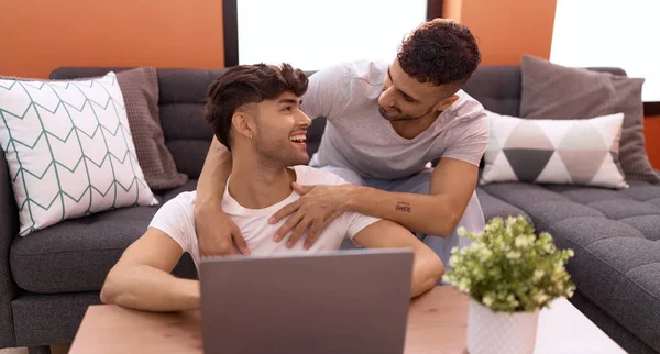Two Hispanic Men Couple Using Laptop Sitting Sofa Home —  Fotos de Stock