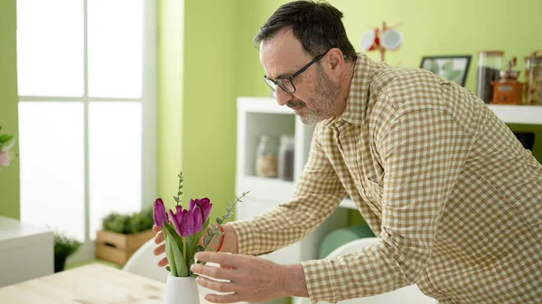 Muž Středního Věku Dává Květináč Stůl Doma — Stock fotografie
