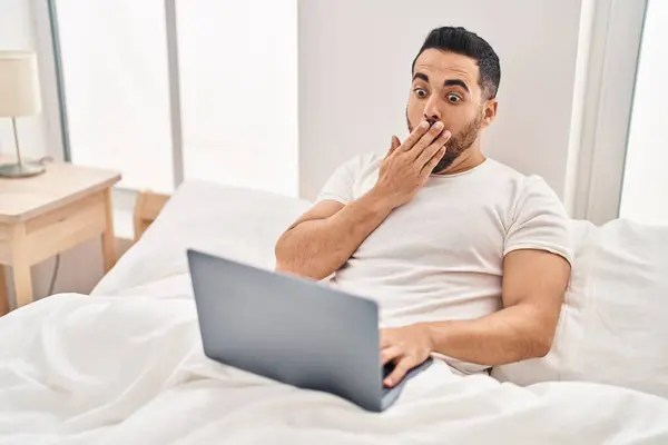 Young Hispanic Man Beard Using Computer Laptop Bed Covering Mouth — Stock Photo, Image