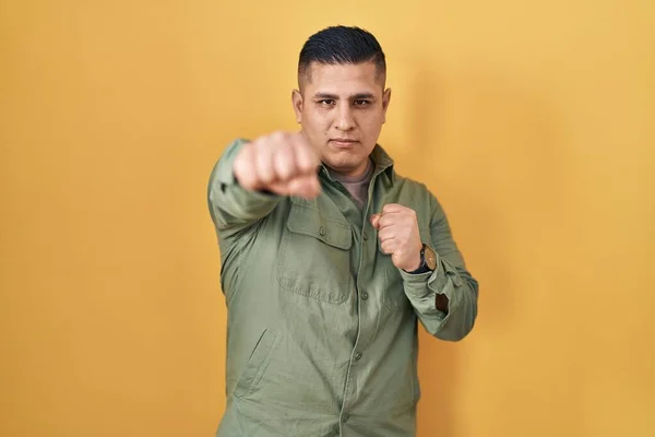 Hispanic Young Man Standing Yellow Background Punching Fist Fight Aggressive — Stock fotografie