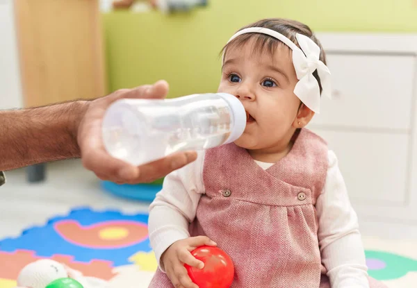 幼稚園でボール飲料水を持っている愛らしいヒスパニック系の赤ちゃん — ストック写真