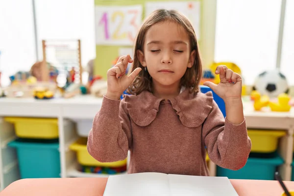 Adorable Hispanic Girl Preschool Student Sitting Table Crossing Fingers Kindergarten — Fotografia de Stock
