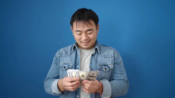 Genç Çinli Adam Gülümsüyor Kendinden Emin Mavi Arka Planda Dolarları — Stok fotoğraf