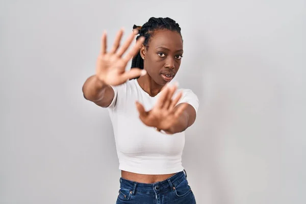 Beautiful black woman standing over isolated background doing frame using hands palms and fingers, camera perspective