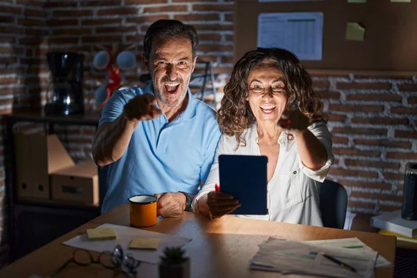 Middle Age Hispanic Couple Using Touchpad Sitting Table Night Pointing — Fotografia de Stock