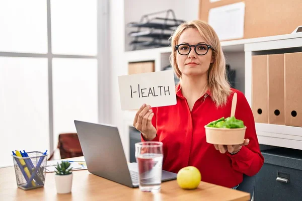 Ofiste Çalışan Sarışın Kadın Sağlıklı Yiyecekler Yiyor Yüzünde Ciddi Bir — Stok fotoğraf