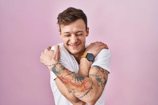 Caucasian Man Standing Pink Background Hugging Oneself Happy Positive Smiling — Stock Photo, Image