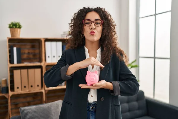 Mulher Hispânica Jovem Segurando Banco Porquinho Olhando Para Câmera Soprando — Fotografia de Stock