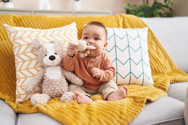 愛らしいHispanic幼児Bittingおもちゃ座っています上のソファにホーム — ストック写真