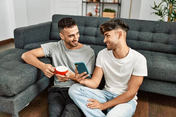 Dos Hombres Hispanos Pareja Usando Smartphone Tomando Café Casa —  Fotos de Stock