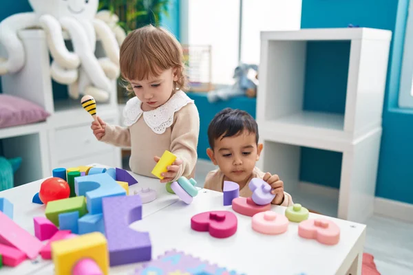 stock image Two kids playing with construction blocks standing at kindergarten