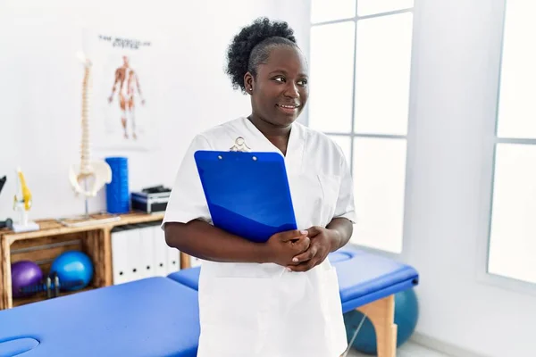 Junge Afroamerikanerin Physiotherapeutenuniform Hält Klemmbrett Klinik — Stockfoto