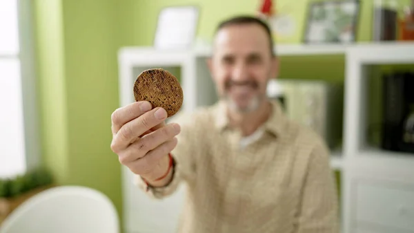 Middle Age Man Holding Cookie Sitting Table Home — ストック写真