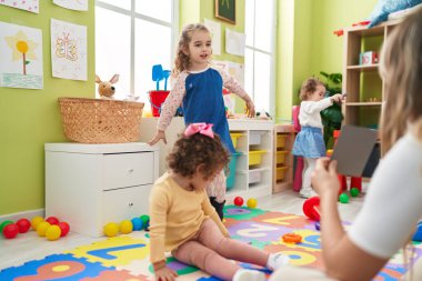 Group of kids having lesson sitting on floor at kindergarten