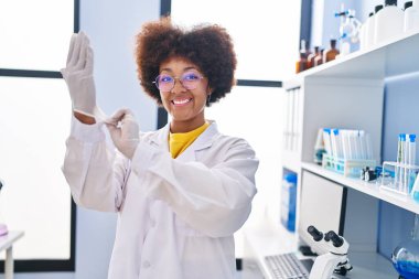African american woman scientist wearing gloves at laboratory