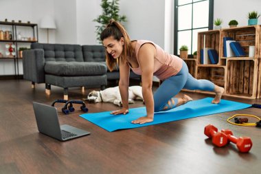 Evde karın kası egzersizi dersi alan kendine güvenen genç bir kadın.