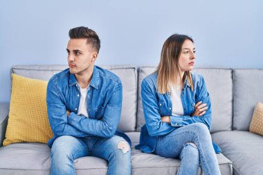 Man and woman couple unhappy sitting on sofa at home