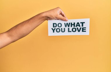 Hand of caucasian man holding paper with do what you love message over isolated white background