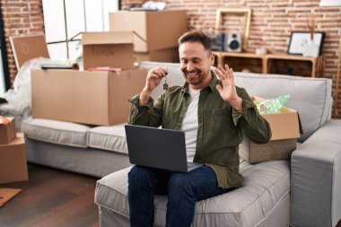 Kafkasyalı genç bir adam yeni evinde video görüşmesi yapıyor.