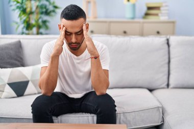 Afrikalı Amerikalı adam evdeki kanepede otururken stresli.