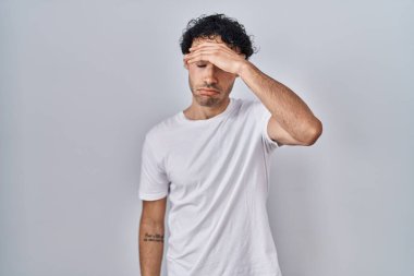 Hispanic man standing over isolated background worried and stressed about a problem with hand on forehead, nervous and anxious for crisis 