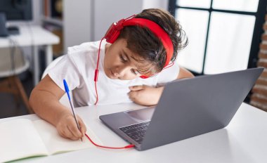 Sevimli İspanyol öğrenci sınıfta dizüstü bilgisayar kullanıyor.