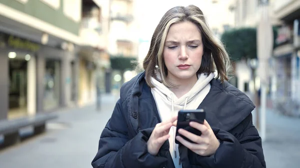 Jovem Loira Usando Smartphone Com Expressão Séria Rua — Fotografia de Stock