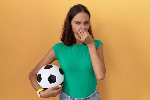 若いヒスパニック系の女性は 鼻の上に指で息を保持し 何か臭いと嫌な 耐え難い匂いを嗅ぐボールを保持 臭いが悪い — ストック写真