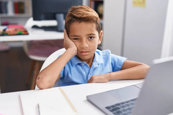 Entzückender Hispanischer Junge Mit Computer Und Müdem Gesichtsausdruck Klassenzimmer — Stockfoto