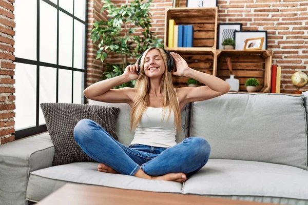 Young Blonde Woman Listening Music Sitting Sofa Home — Stockfoto