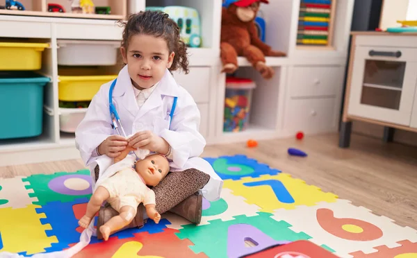 Urocza Latynoska Dziewczyna Mundurze Lekarza Bandaż Ramię Baby Doll Przedszkolu — Zdjęcie stockowe