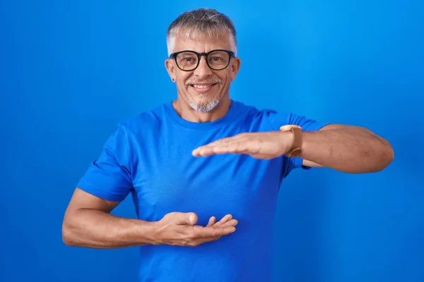 Hispanic Man Grey Hair Standing Blue Background Gesturing Hands Showing — 스톡 사진