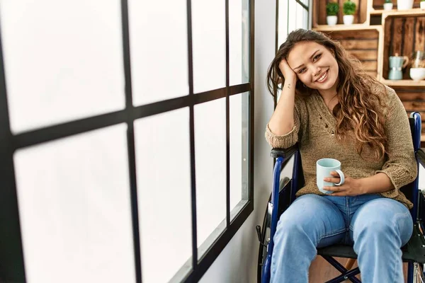 若い美しいですヒスパニック系の女性は自宅で車椅子に座ってコーヒーを飲む — ストック写真