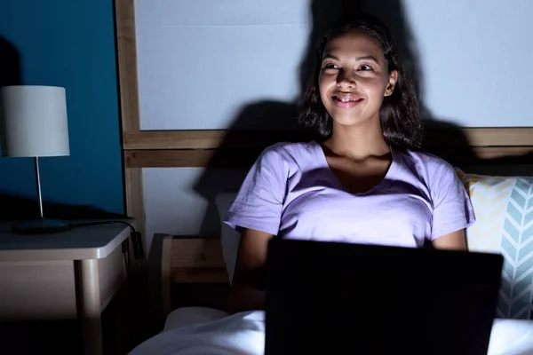 年轻的非洲裔美国女人坐在卧室的床上用笔记本电脑 — 图库照片