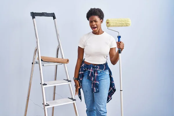Mulher Afro Americana Segurando Pintor Rolos Irritado Louco Gritando Frustrado — Fotografia de Stock