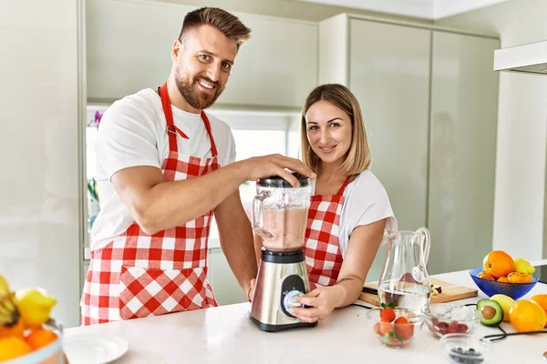Casal Jovem Sorrindo Confiante Fazendo Smoothie Usando Liquidificador Cozinha — Fotografia de Stock