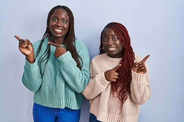 Due Donne Africane Piedi Sfondo Blu Indicando Parte Preoccupato Nervoso — Foto Stock