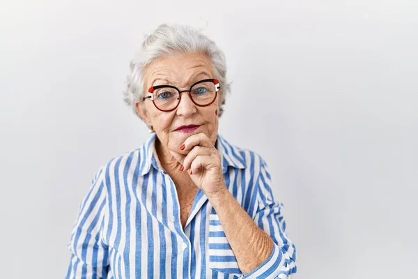 Starsza Kobieta Siwymi Włosami Stojąca Nad Białym Tłem Ręką Podbródku — Zdjęcie stockowe