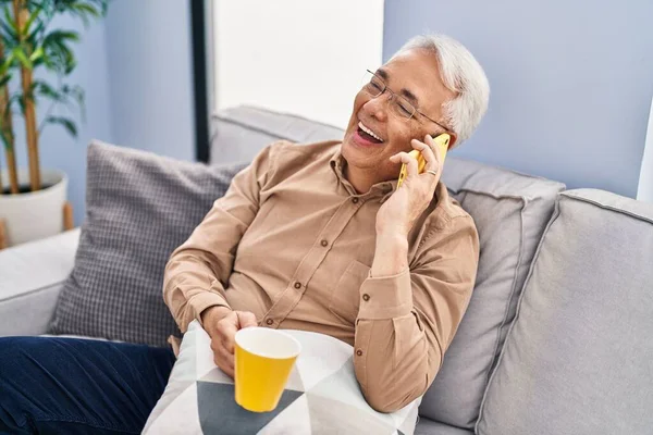 Senior Man Drinking Coffee Talking Smartphone Home — Foto de Stock