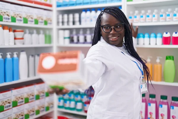 Afrikaans Amerikaanse Vrouw Apotheker Glimlachen Zelfverzekerde Holding Pakket Bij Apotheek — Stockfoto