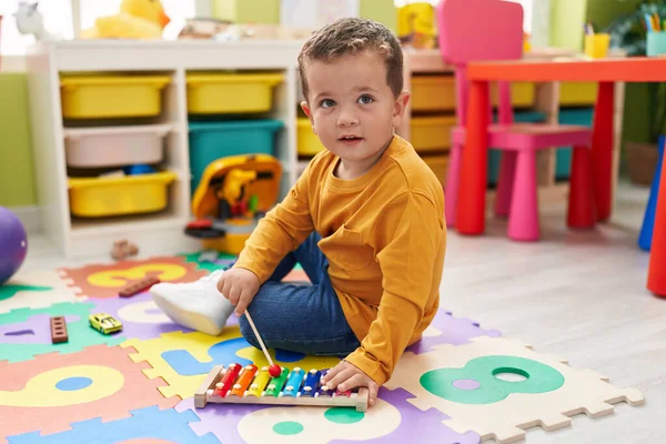 愛らしいCaucasian男の子遊びますXylophone座っている床に幼稚園 — ストック写真