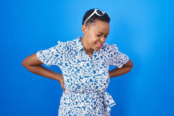 アフリカ系アメリカ人女性は青い背中の痛みに苦しみ手で背中に触れ筋肉痛 — ストック写真