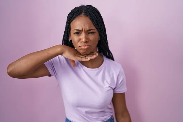 Africano Americano Mulher Com Tranças Sobre Fundo Rosa Cortando Garganta — Fotografia de Stock
