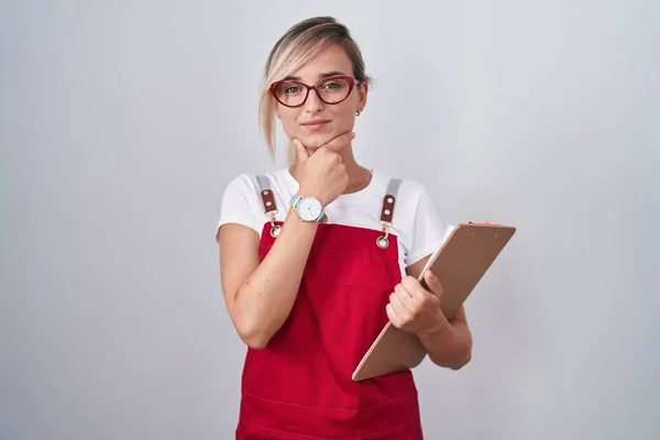 Young Blonde Woman Wearing Waiter Uniform Holding Clipboard Looking Confident — 图库照片