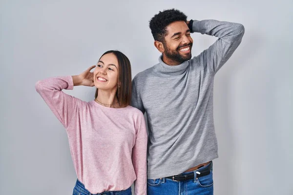 Young Hispanic Couple Standing Together Smiling Confident Touching Hair Hand — Stockfoto